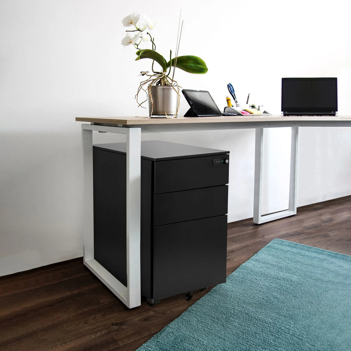 Musta metallinen rullalaatikosto COLOR OS I vaalean puisen työpöydän alla, valmistaja hjh OFFICE