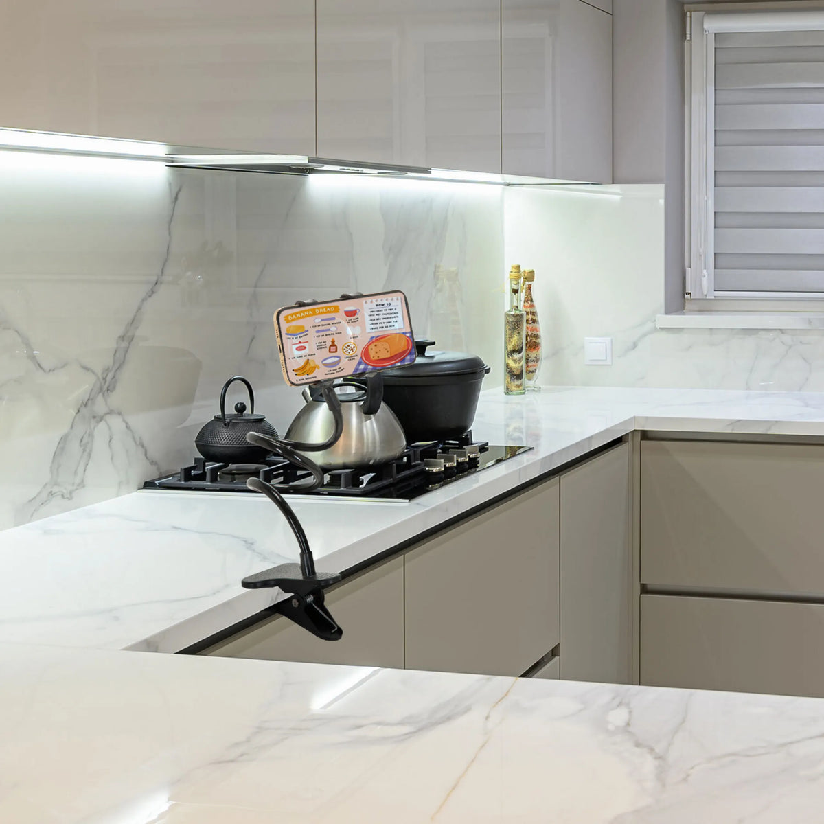 Musta matkapuhelimen & tabletin pidike FLEXMOBI keittiön työtasolla, valmistaja hjh OFFICE