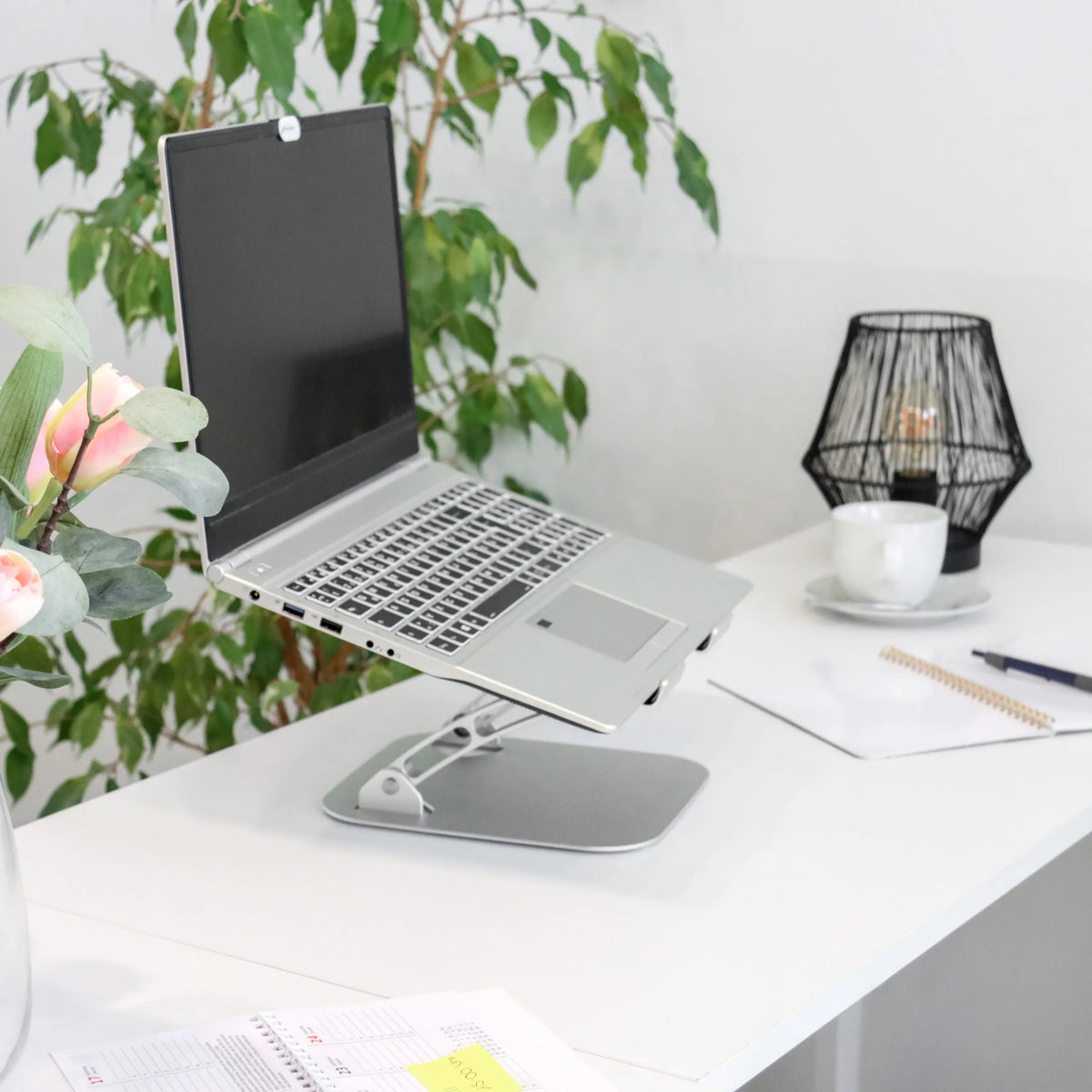 Hopeinen kannettavan tietokoneen alusta LAPTOP STAND säädettävällä telineellä valkoisella työpöydällä, valmistaja hjh OFFICE