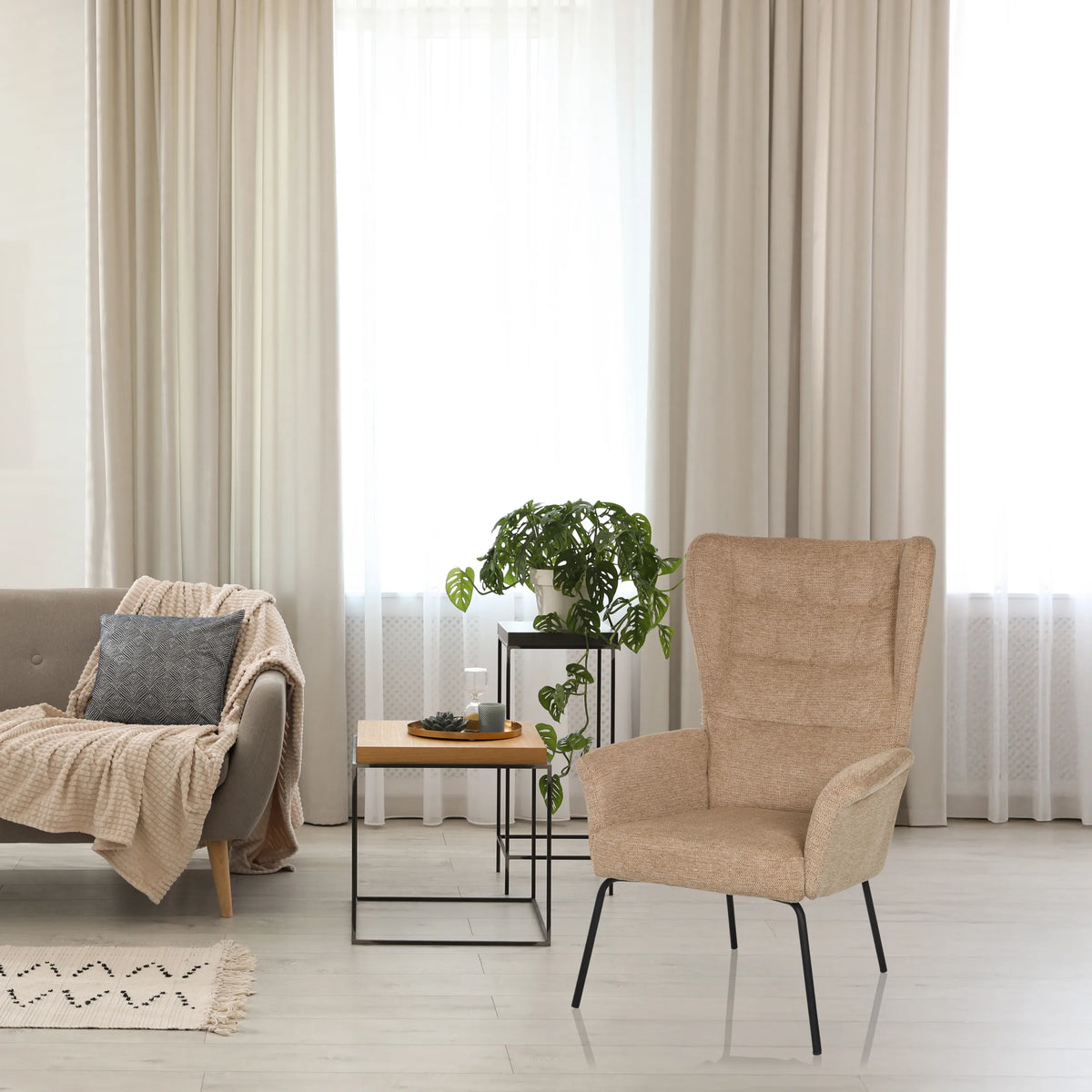 Beige pehmustettu nojatuoli HAVENIO, jossa on korkea selkänoja ja mustat metallijalat, valmistaja hjh LIVING