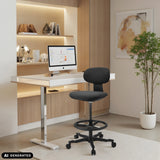 Musta WORK MF2 -työtuoli, jossa on jalkarengas ja pyörät, valkoisen työpöydän edessä, valmistaja hjh OFFICE (tekoälyllä luotu kuva)