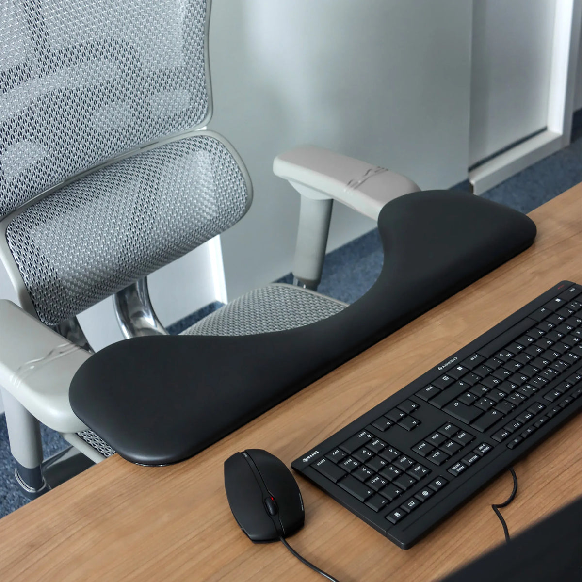 Musta RELEX RT2 -käsinoja työpöydällä näppäimistön ja tietokonehiiren vieressä, valmistaja hjh OFFICE