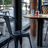 Musta Bistrotuoli VANTAGGIO BRUSH, jossa on kaareva selkänoja, pyöreän pöydän ääressä, valmistaja hjh OFFICE