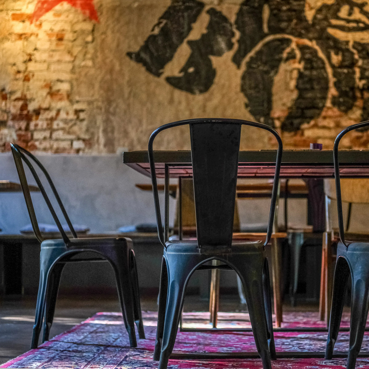 Mustan metallisen VANTAGGIO BRUSH-bistrotuolin takanäkymä pöydän ääressä, valmistaja hjh OFFICE