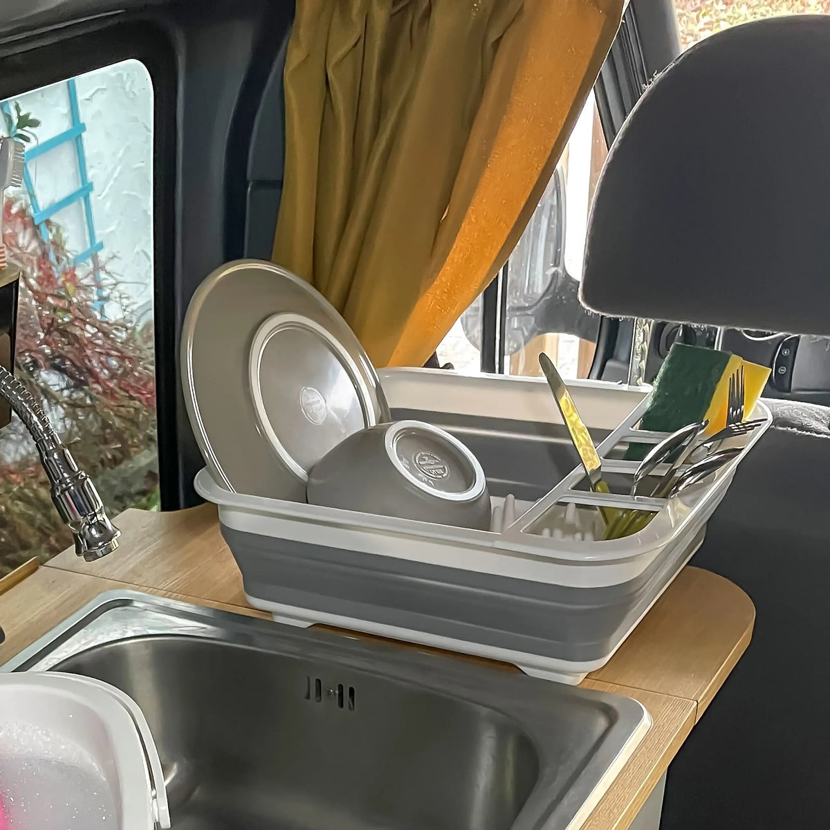Harmaanvalkoinen kokoontaitettava kontti CLEAN SIL astioineen ja aterimineen työtasolla, valmistaja hjh OFFICE