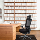 Musta High End -toimistotuoli NOVA PRO I niskatuella ja verkkoselkänojalla puisen työpöydän edessä, valmistaja hjh OFFICE