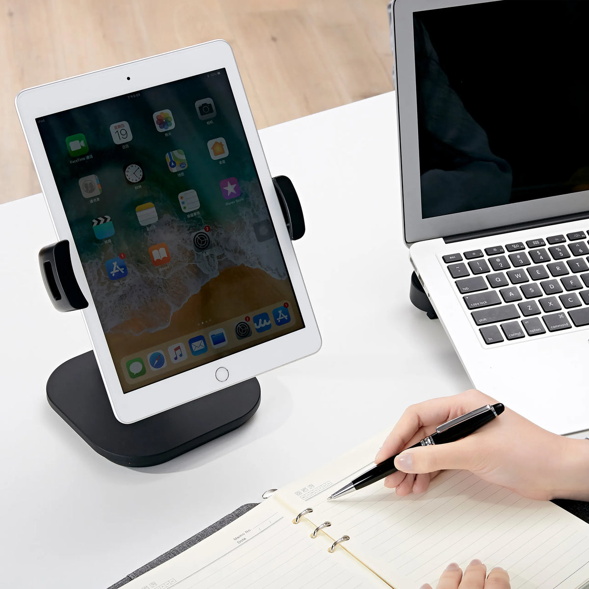 Musta Matkapuhelimen & tabletin pidike FLEXMOBI IV ja siinä oleva tabletti valkoisella työpöydällä, valmistaja hjh OFFICE